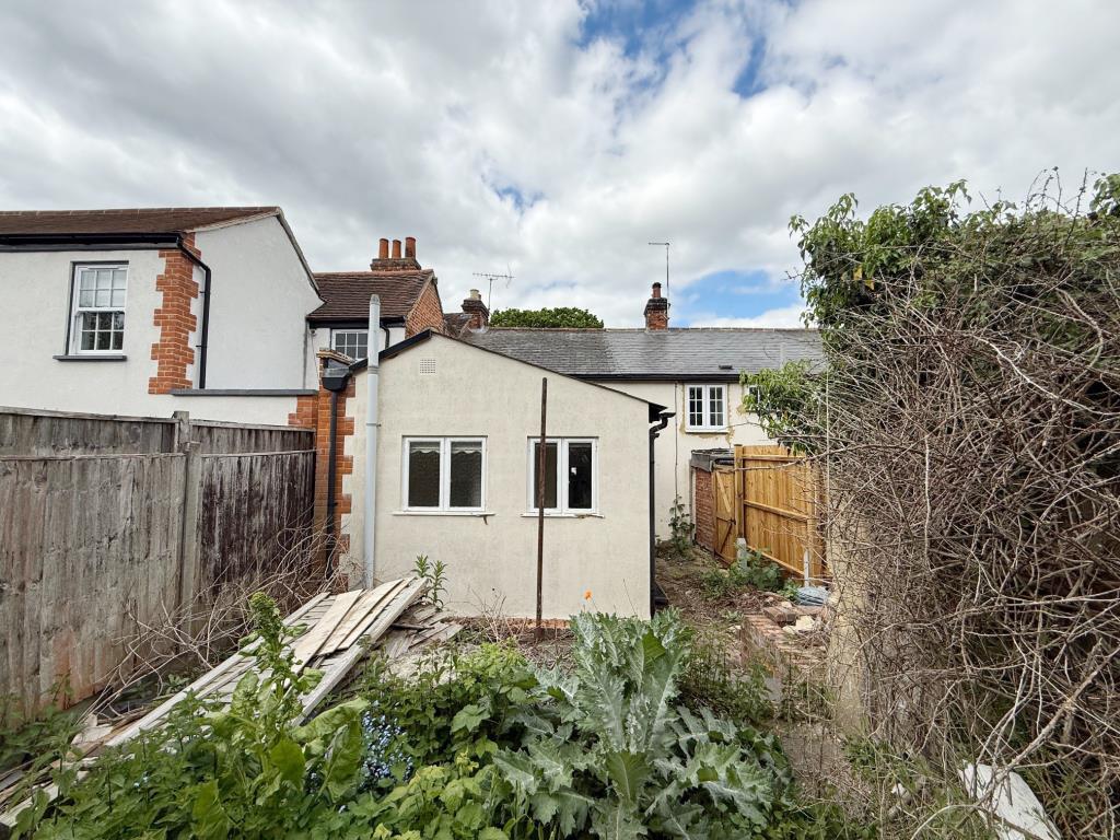 Lot: 165 - MID-TERRACE COTTAGE FOR IMPROVEMENT - Rear elevation and overgrown rear garden